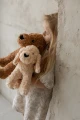 Dziewczynka trzymająca pluszowe pieski Maltipoo w beżowym i brązowym kolorze