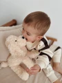 Dziecko przytulające jasnobeżowego pieska pluszowego Maltipoo